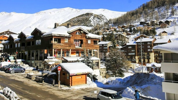 A snow-covered mountain town with wooden buildings, a clear sky, and a 'No Entry' sign. - Family Apartment in La Foux D'allos (Allos)