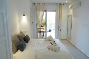 A bedroom with a bed, pillows, a mirror, and a view of the outside. - Vue Majorelle: 2 suites- Private terrace-parking area (Marrakesh)