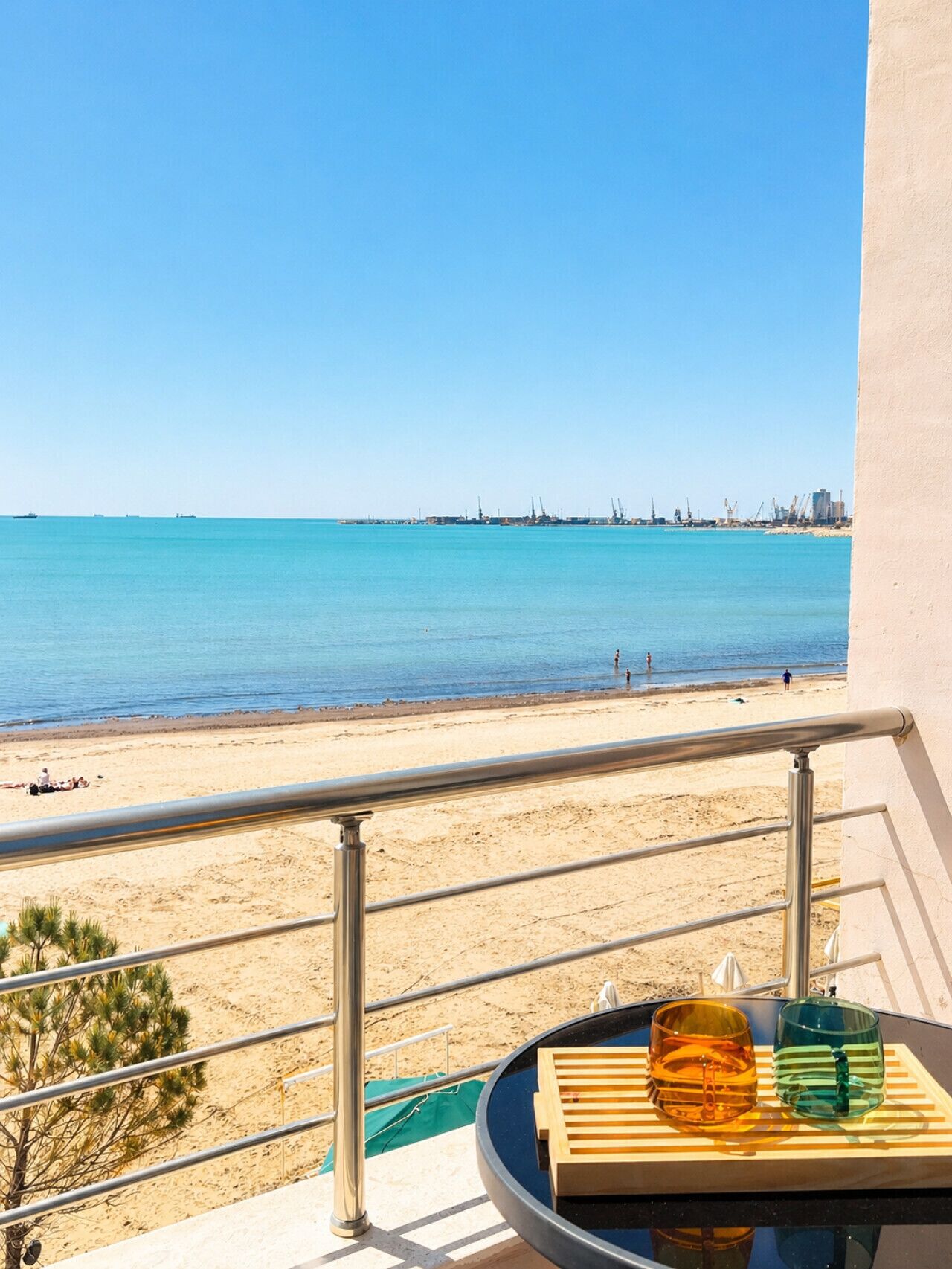 A balcony with a view of a beach and the sea.