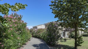A pathway lined with flowering bushes leading to a building with a tiled roof. - Spacious Provence House for Eight (Saint-Saturnin-les-Avignon)