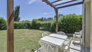 An outdoor patio with a wooden pergola, a white table, and chairs. - Spacious Provence House for Eight (Saint-Saturnin-les-Avignon)