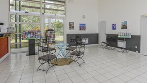 A spacious indoor area with a reception desk, a bulletin board, and a seating area with chairs and a small table. - Spacious Provence House for Eight (Saint-Saturnin-les-Avignon)