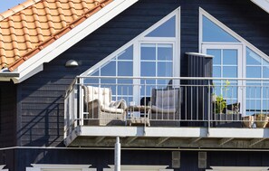 Ein Balkon mit Korbmöbeln und Topfpflanzen.