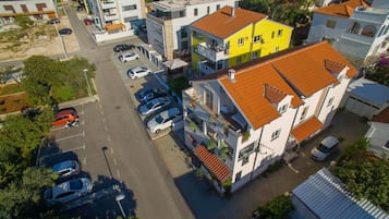 Luchtbeeld van een woongebied met meerdere gebouwen, een parkeerplaats en een straat.