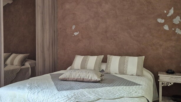 A bedroom with a bed, pillows, a bedside table, and a nightstand. - Villa Dans le Golfe de Saint-tropez (Cogolin)