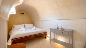 A bedroom with a bed, bedside table, and a window. - Casa Adamare - Charming Luxury Stay (Ostuni)