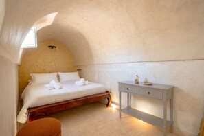 Una camera da letto con un letto, un comodino e una finestra.