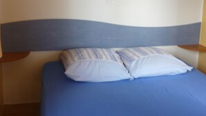 Ein Schlafzimmer mit einem Bett, einem Kopfteil und Einbauschränken darüber.