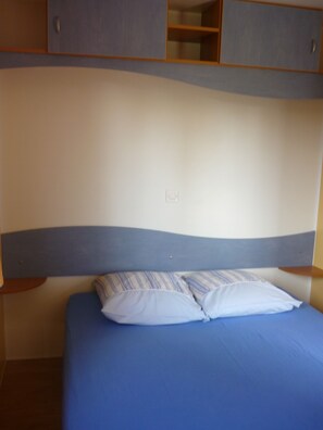 Ein Schlafzimmer mit einem Bett, einem Kopfteil und Einbauschränken darüber.