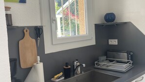 Una cocina con lavavajillas Bosch, una ventana, un tostador y un lavabo.