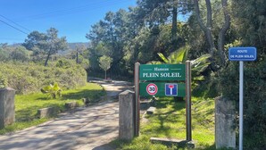 Una carretera rural con un cartel que indica 'Hameau Plein Soleil' y un límite de velocidad de 30.