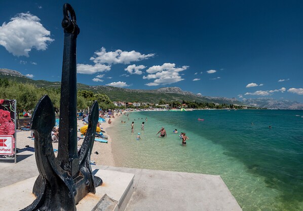 Playa en los alrededores, playa de arena blanca y toallas de playa 