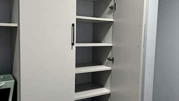 A closed walk-in closet with multiple shelves and a handle.