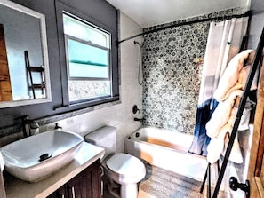 Een badkamer met een wastafel, toilet en bad.