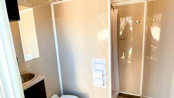 Ein kleines Badezimmer mit Toilette, Waschbecken und Spiegel.