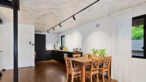Une cuisine moderne avec une table à manger en bois, des chaises et des plantes en pot.