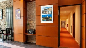 A hotel lobby with a stone wall, a reception desk, and a corridor leading to rooms. - 2-room Dinan Flat for 4 (Dinan)