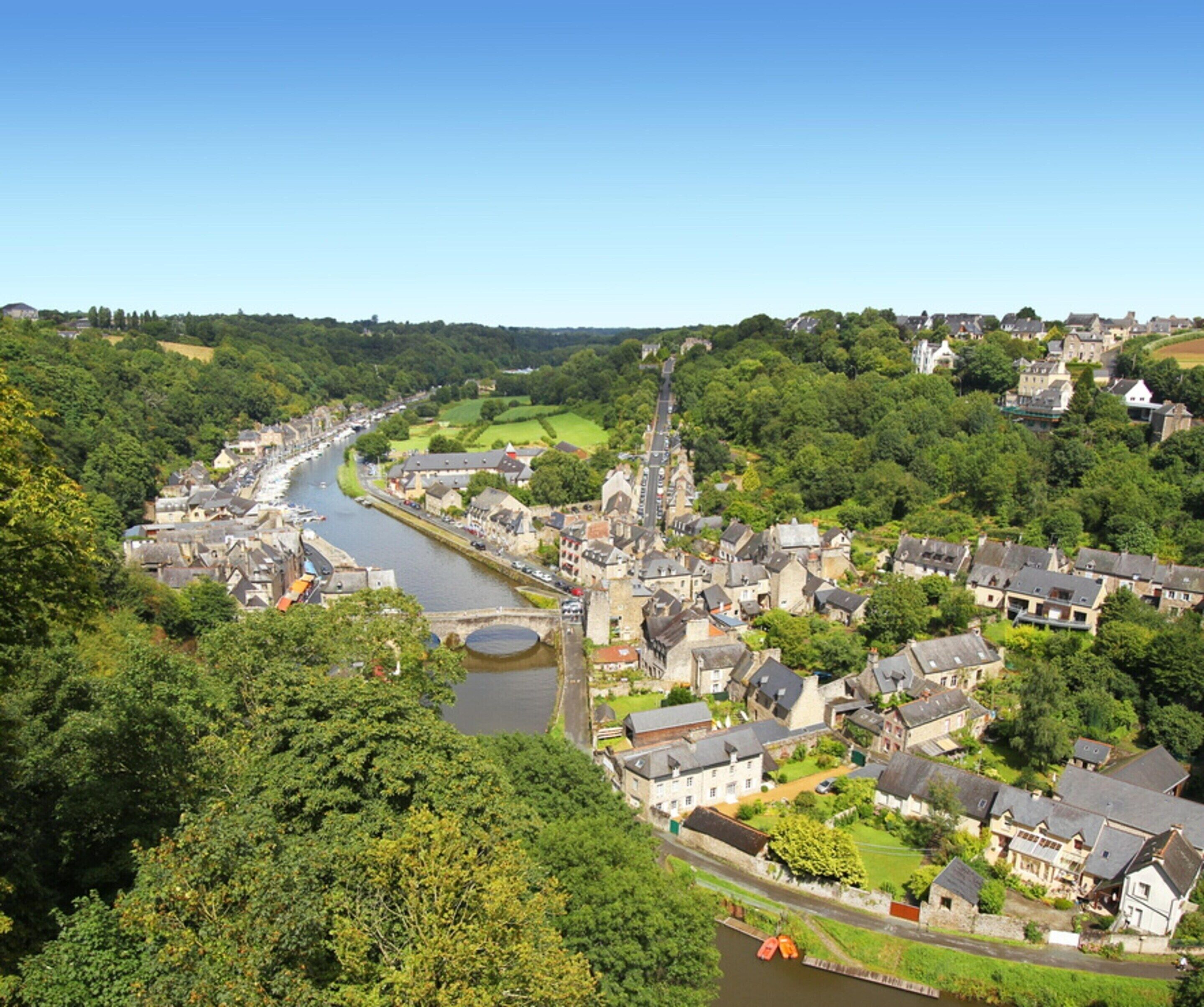 A riverside town with historic buildings, a bridge, and a canal.