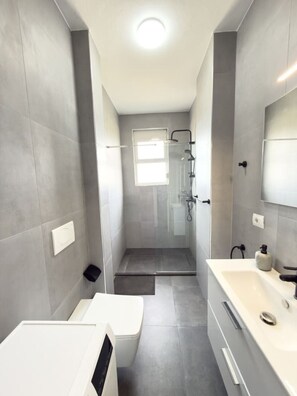 A modern bathroom with a shower, toilet, and sink. - Tiara Beach Apartment (Durrës)