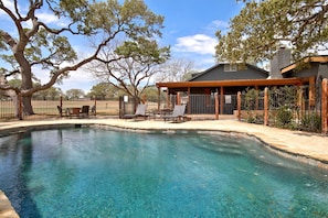 A clear swimming pool with lounge chairs and a covered patio area. - Luxurious German-Style Ranch Vacation Rental with Pool Access and Stunning Views in Bergheim, Texas (Bergheim)