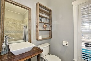 A bathroom with a white sink, a toilet, and a mirror with a wooden frame. - Luxurious German-Style Ranch Vacation Rental with Pool Access and Stunning Views in Bergheim, Texas (Bergheim)