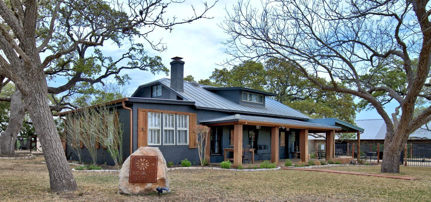 A house with a metal roof, a chimney, and a porch with outdoor seating.