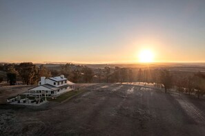 Une maison avec une grande allée et une vue sur le coucher de soleil.
