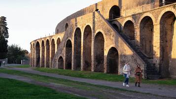 A historic stone building with multiple arches and a staircase.