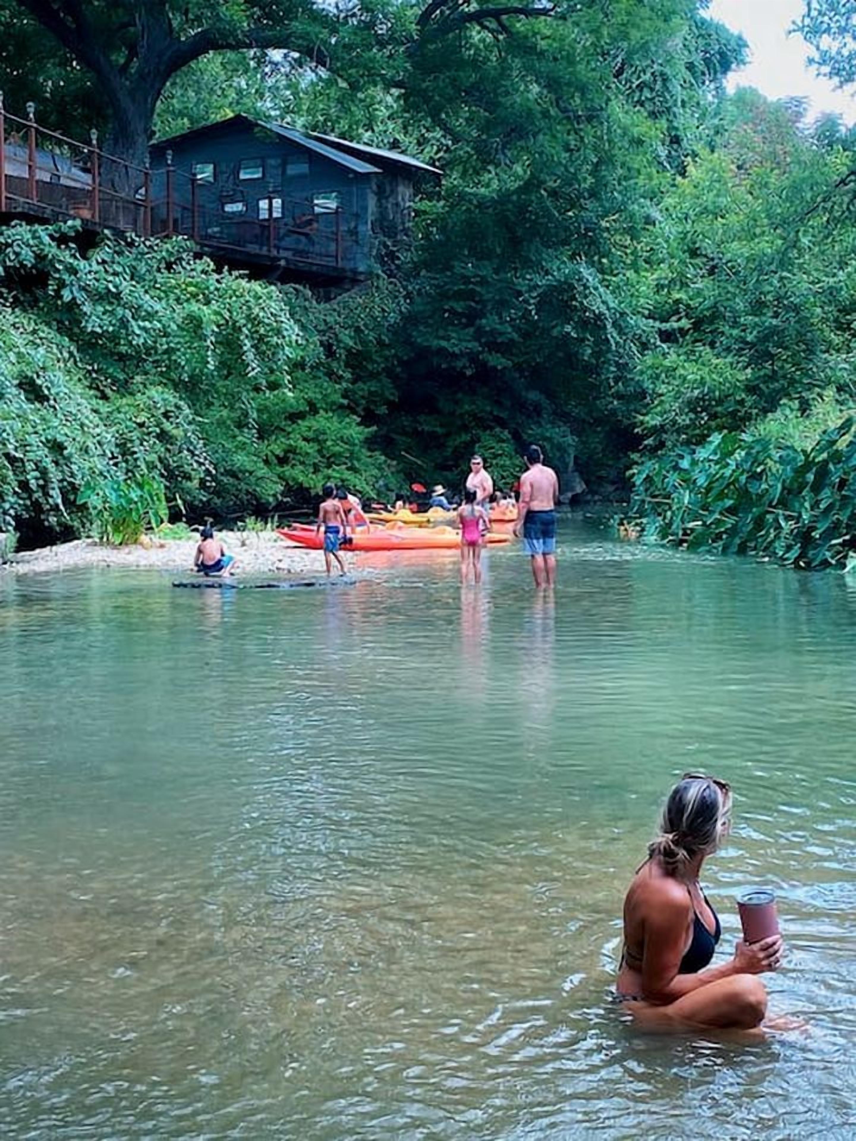 Ein Fluss, auf dem Menschen Kanu fahren und schwimmen.