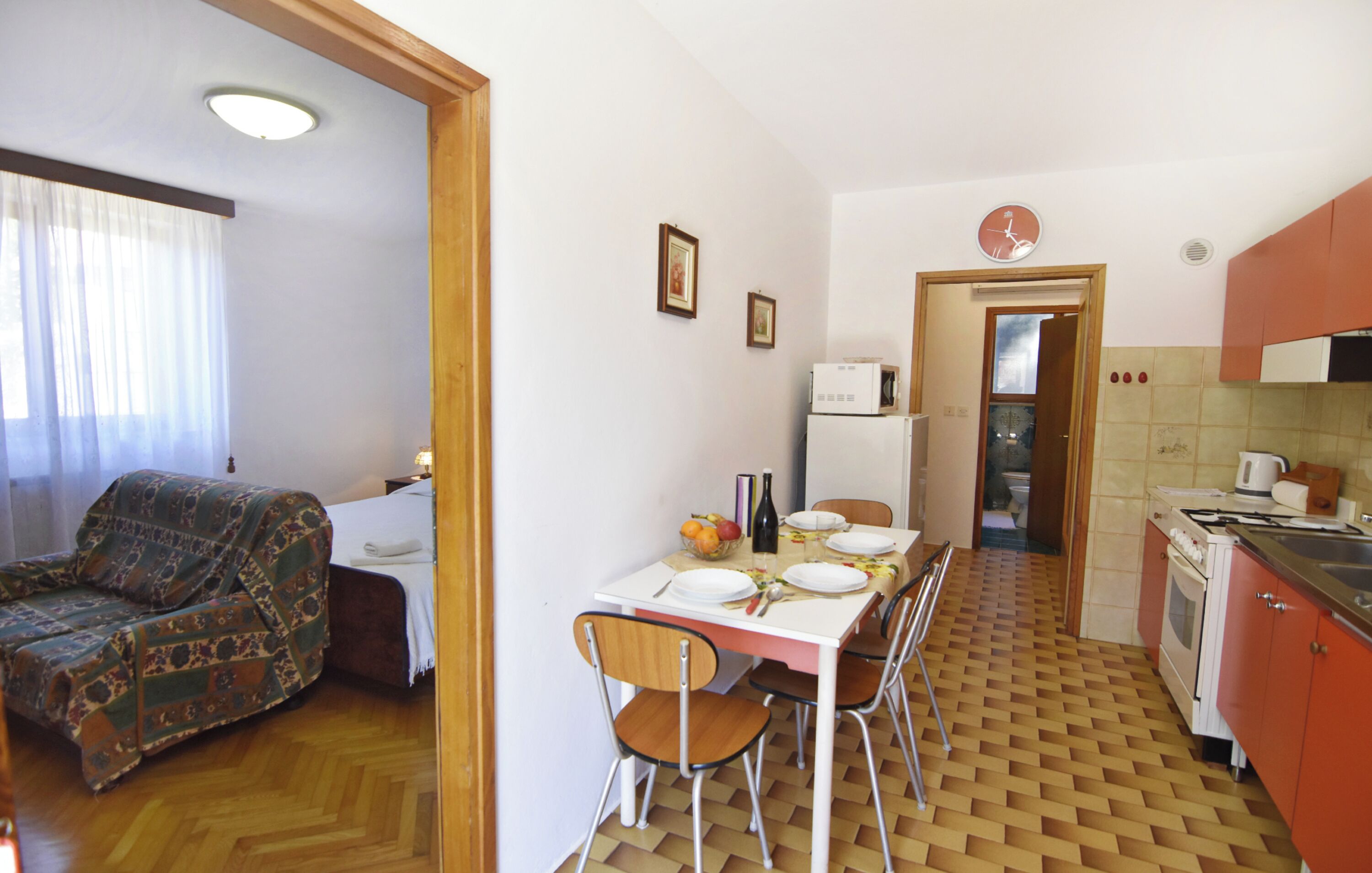 A compact living space with a dining area, kitchen, and a sofa in the living room.