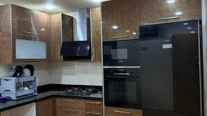 Una cocina moderna con electrodomésticos de acero inoxidable, armarios de madera y un microondas integrado.