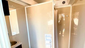 A compact bathroom with a toilet, sink, and mirror. - Nature Getaway on the San Marcos River - Secluded Safari Tent near Kingsbury, Texas (Kingsbury)