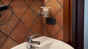 A bathroom with a white sink, a mirror, and a tiled wall. - Oasis aloe vera (Troina)