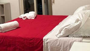 A hotel room with a bed, a nightstand, a window with a view, and a door. - Oasis aloe vera (Troina)