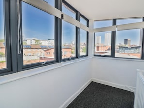 A room with large windows, a black carpet, and a view of buildings. - Rickman Apartment (Birmingham)