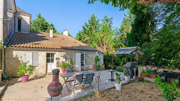 A rustic stone house with a tiled roof, outdoor seating, and potted plants. - Bed and Breakfast 'Chambre Orée Du Jour' with Shared Terrace, Shared Garden and Wi-Fi (Saint-Porchaire)