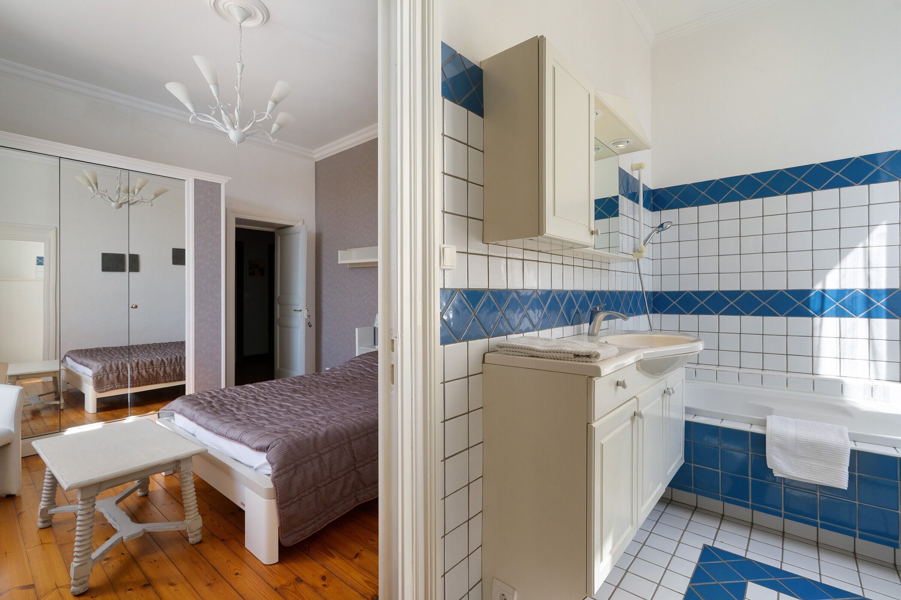 Un dormitorio con cama, mesita de noche y lámpara colgante.