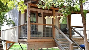A wooden deck with a metal railing, a staircase, and a door marked with the number 16.