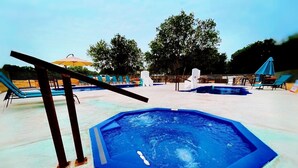 A swimming pool with lounge chairs and umbrellas.