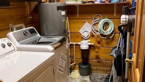 Ett litet och praktiskt tvättrum med tvättmaskin, torktumlare och ett litet handfat.