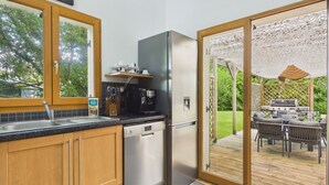A kitchen with a dishwasher, a coffee maker, and a refrigerator. - House for 8 with bbq, big garden and terrace (Fouesnant)