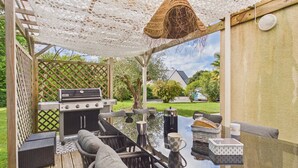An outdoor patio with a grill, wicker furniture, and a view of the backyard. - House for 8 with bbq, big garden and terrace (Fouesnant)