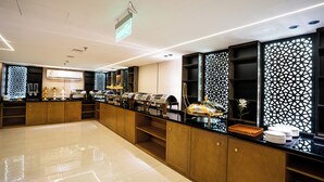 A modern hotel lobby with a long reception desk, a large air conditioning unit, and a decorative wall with a geometric pattern. - Alhijrah View 2 Hotel (Makkah)