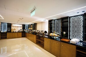 A modern hotel lobby with a long reception desk, a large air conditioning unit, and a decorative wall with a geometric pattern. - Alhijrah View 2 Hotel (Makkah)
