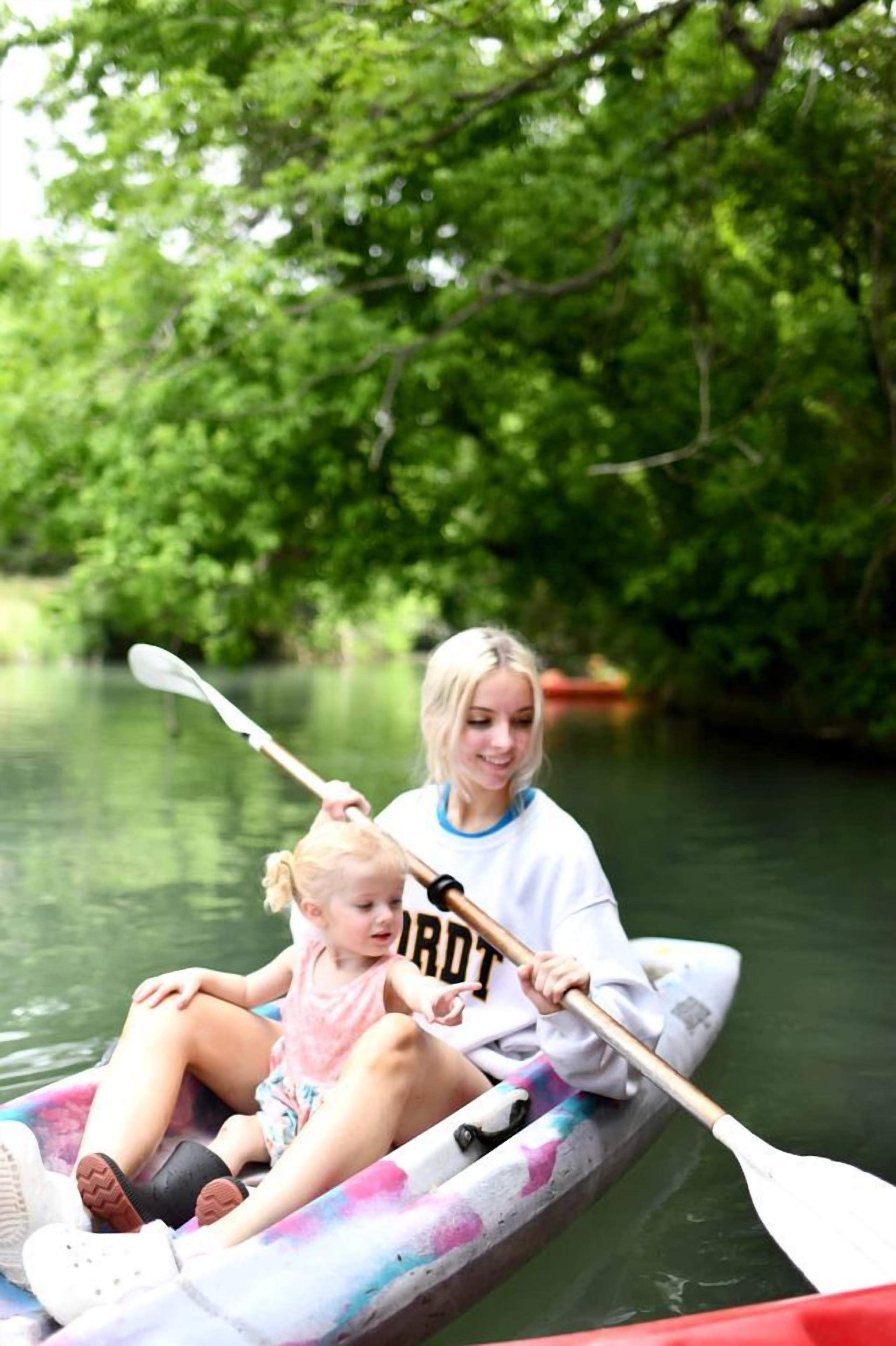 Una persona en kayak en un río rodeado de vegetación.