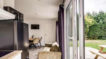 Een moderne keuken met een inbouwoven en een eethoek met een tafel en stoelen.