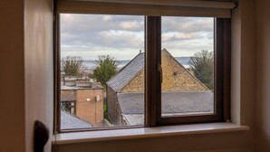 Janela com vista para prédios e um céu nublado.