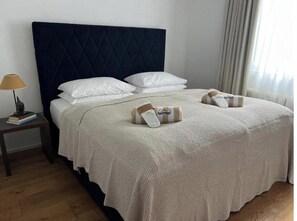 A neatly made bed with a quilted headboard, white pillows, and a folded towel on the bed. - Hideaway in Strobl with bathing area and breakfast at partner hotel (Strobl)