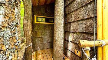 A wooden interior with a wooden floor, a window, and a rope barrier.