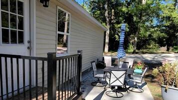 A house with a porch, outdoor furniture, and potted plants.